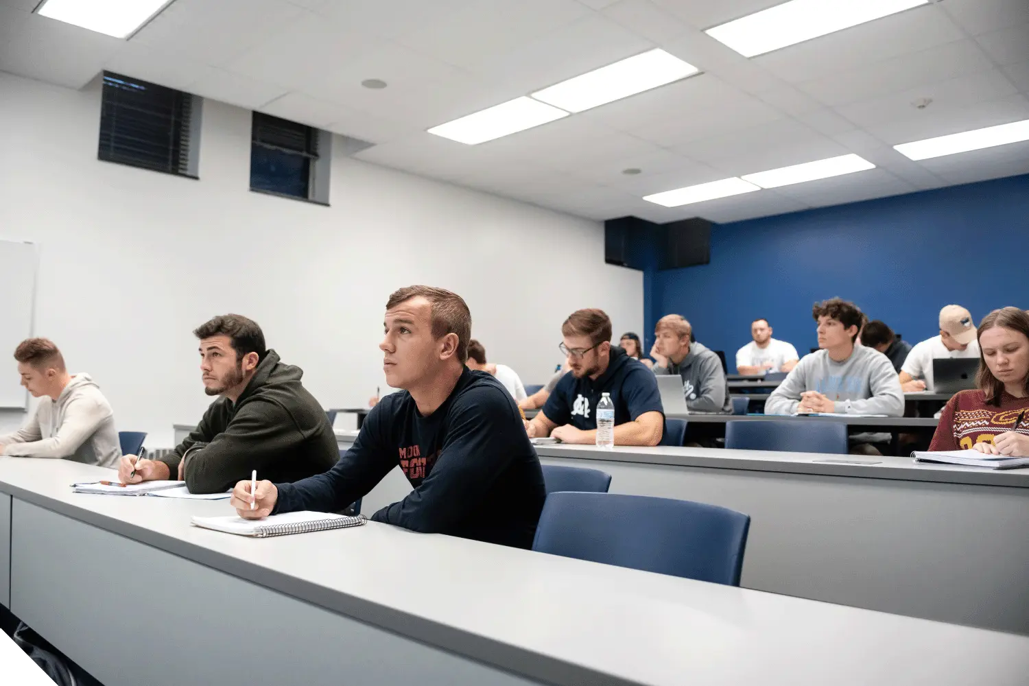 Marietta College Students sitting in a classroom and taking notes while listening to a lecture.