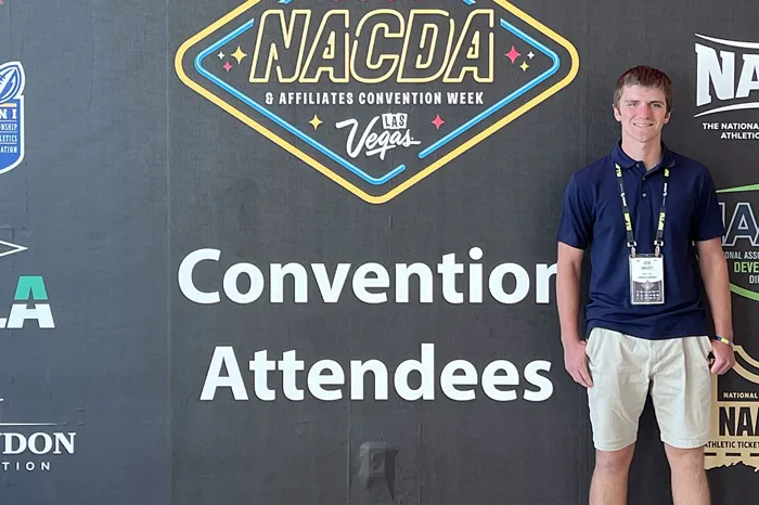 Josh Mudgett standing in front of the NACDA sign