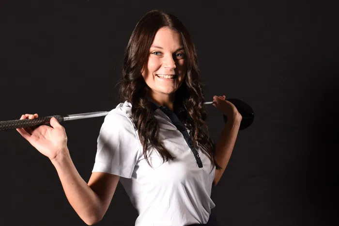 Women's golf with club over shoulders