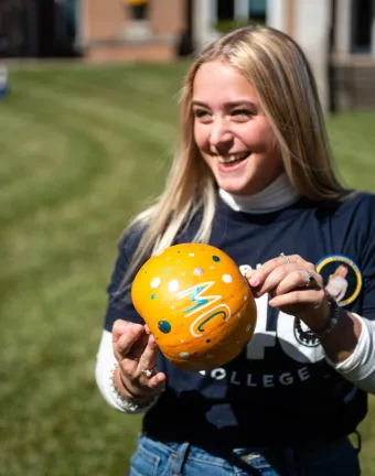 A Marietta College student holds a decorated pumpkin during Festifall