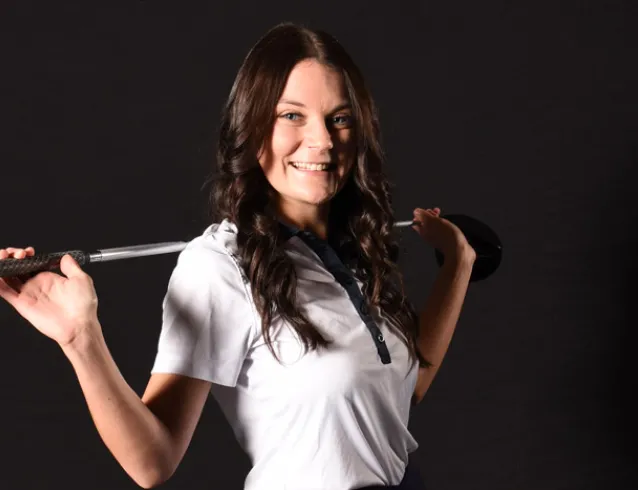 Women's golf with club over shoulders