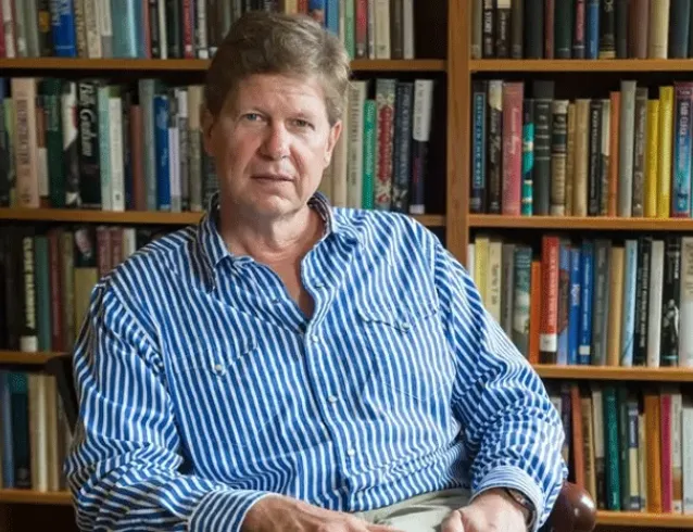 Randall Balmer seated in front of a bookcase