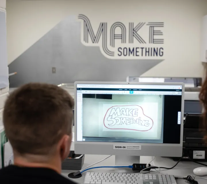 A Marietta College student majoring in graphic design works on a project at a computer in the Deem Design Center