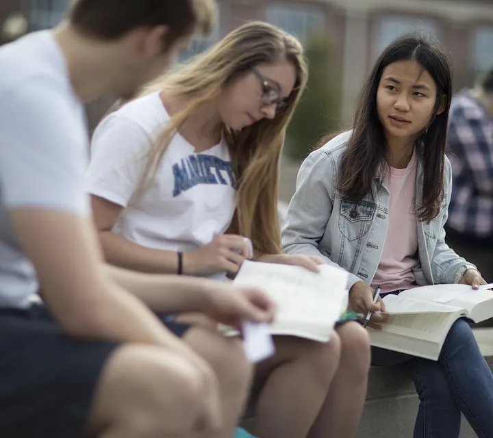Three Marietta College students study outdoors