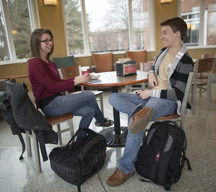 two students enjoy a drink in the Legacy Library