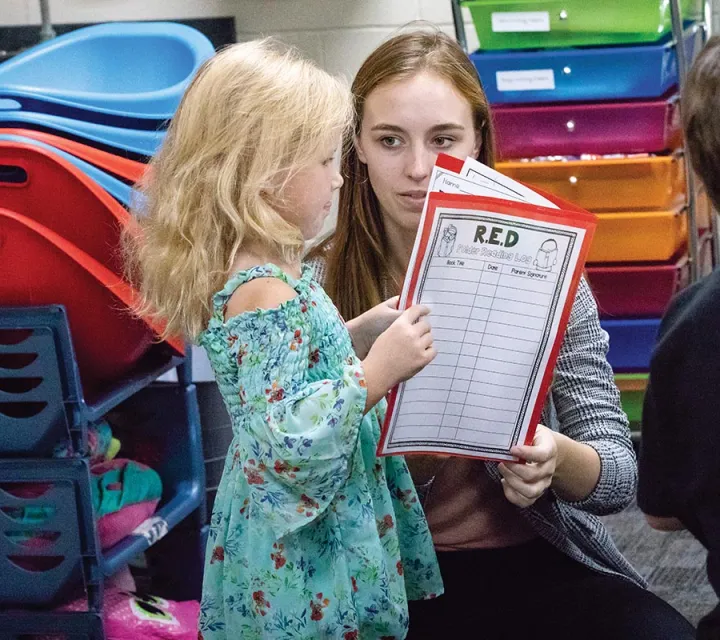 Education student Alexis Swisher ’20 goes over a reading log with a Beverly-Center Elementary student
