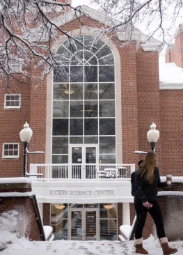 A student walks past the snow covered entrance to Rickey Science Center