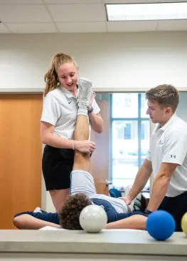 Students in the Master of Athletic Training Program work hands on with an athlete.