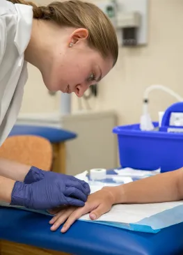 A Marietta College Physician Assistant Studies graduate searches for a vein.