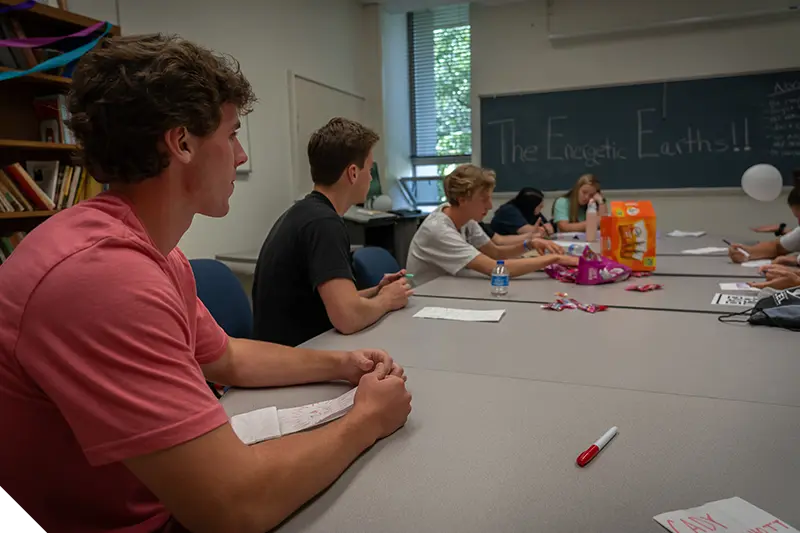 A Marietta College student laughs while sitting at a table with other students