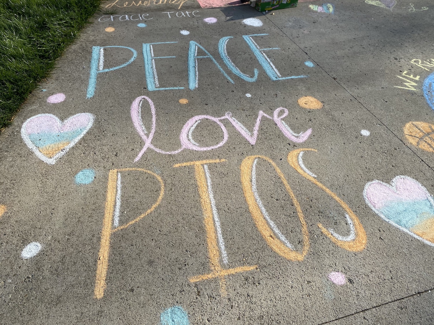 Sidewalk chalk which reads: PEACE love PIOS