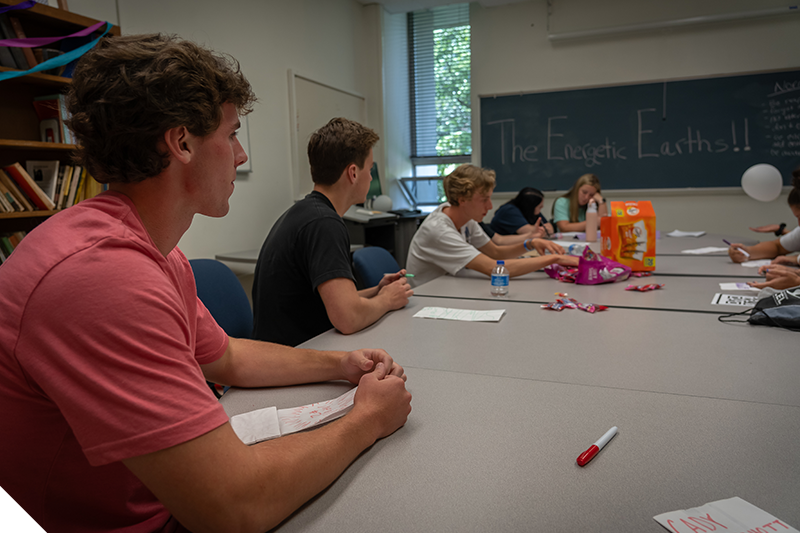 A Marietta College student laughs while sitting at a table with other students