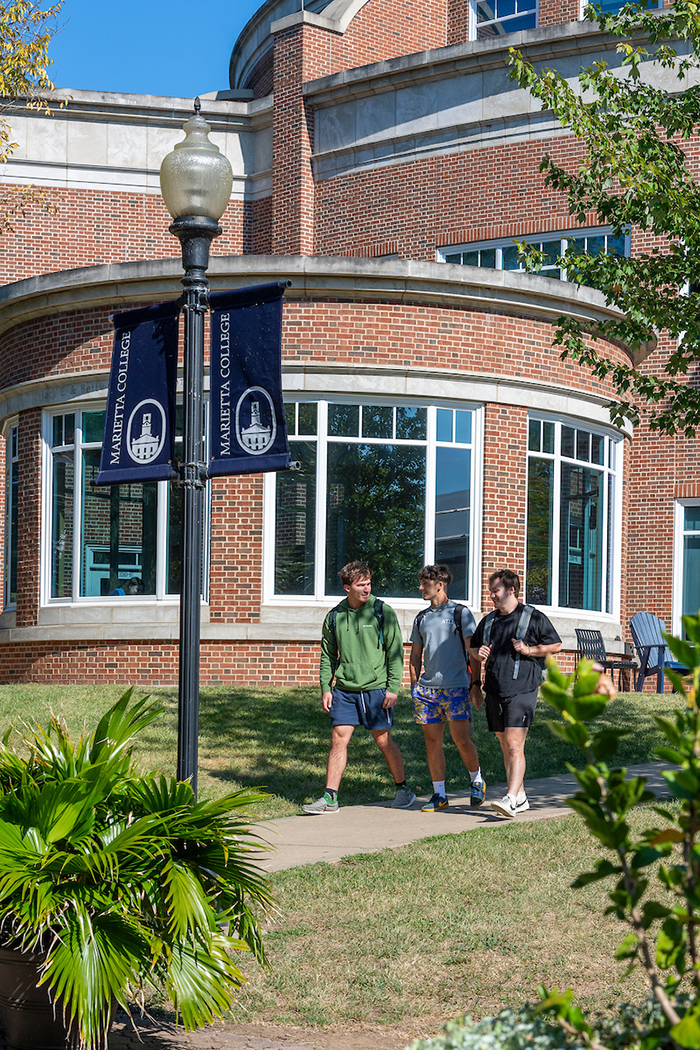 Three boys walk past library
