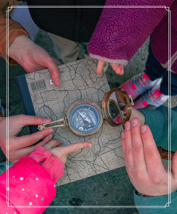 Adults' and childrens' hands pointing to a compass