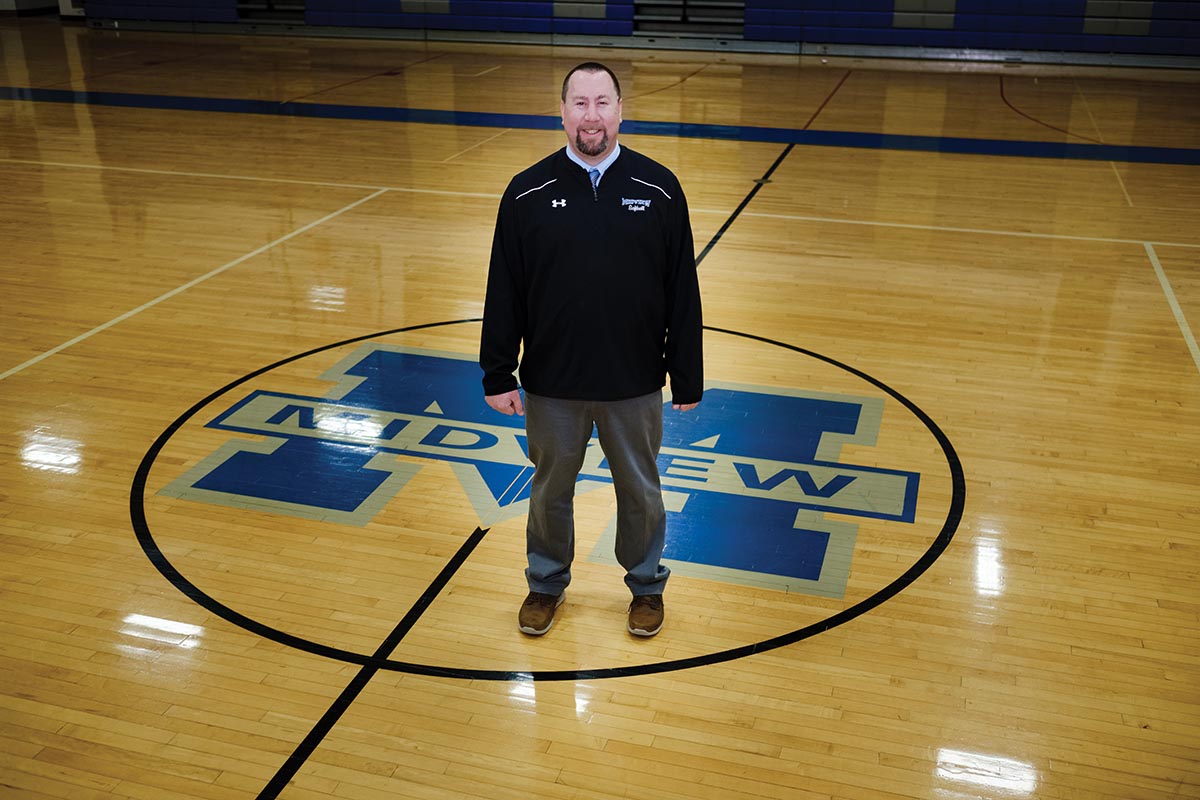 Dan May stands at center court for a photo