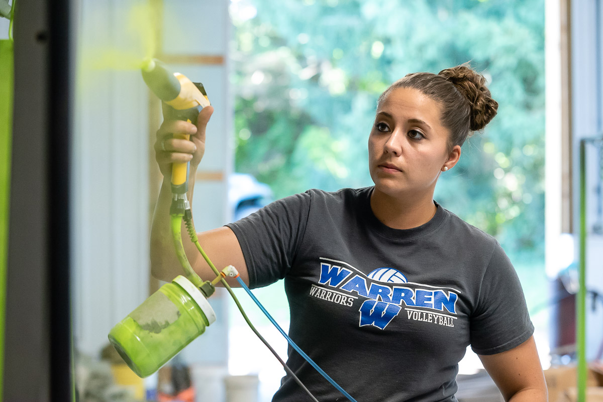 Marietta College Alumna Paige Griffith powdercoats a metal piece