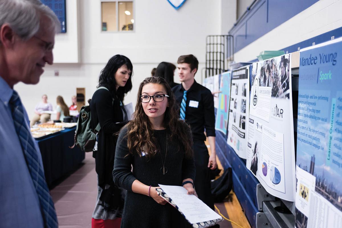 Mandee Young ’18 discusses her internship with Mediavest | Spark with Dr. Bob Van Camp during the poster session of All Scholars Day.