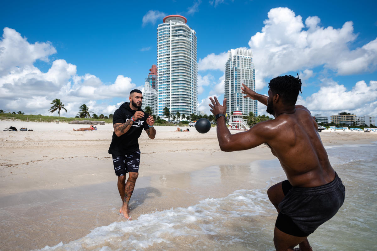 Luis Garcia '16 throws a weight to his client while standing in the water at Miami Beach