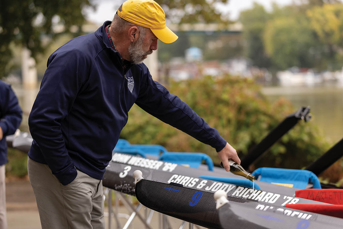 Jeff Hugel â77 christens the Chris & Jody Richard â78 shell during a special ceremony at the boathouse during Homecoming weekend.