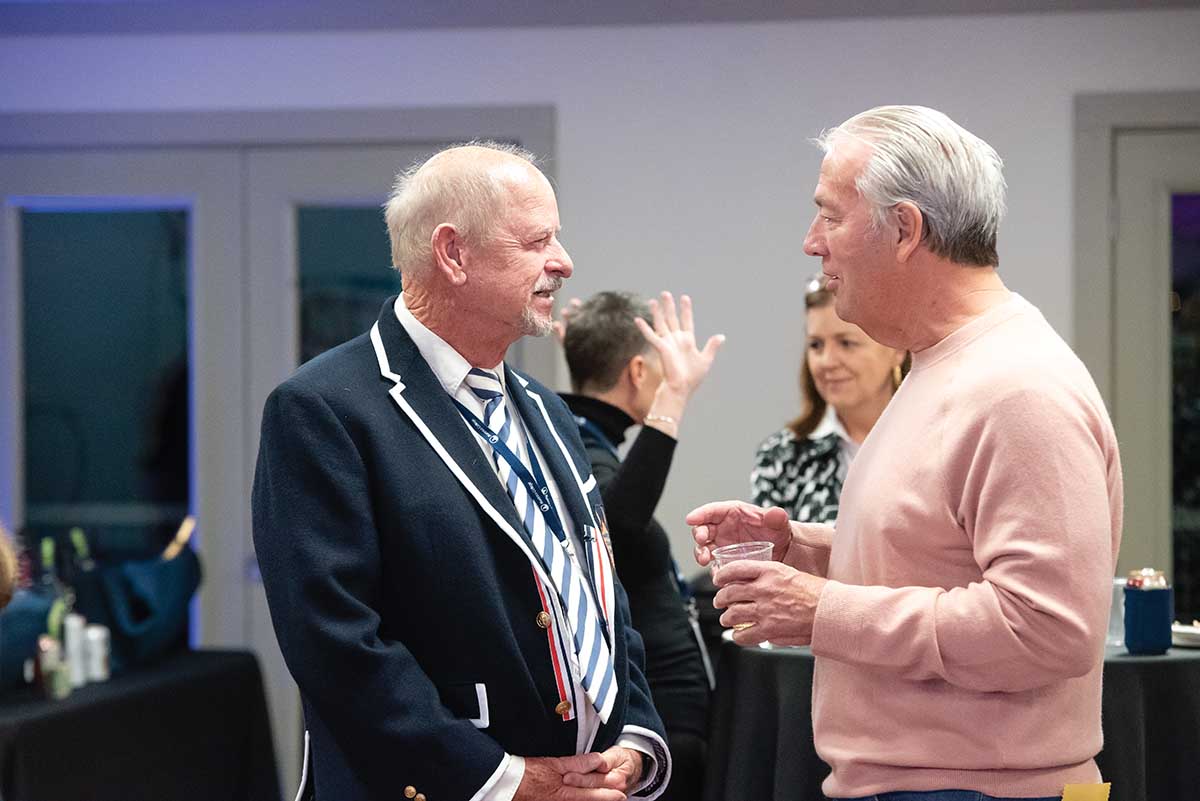 Tom Feaster ’69 speaks with Frank Glaser ’71 during the 150th anniversary celebration of Marietta Crew at the Lindamood-Van Voorhis Boathouse in October.