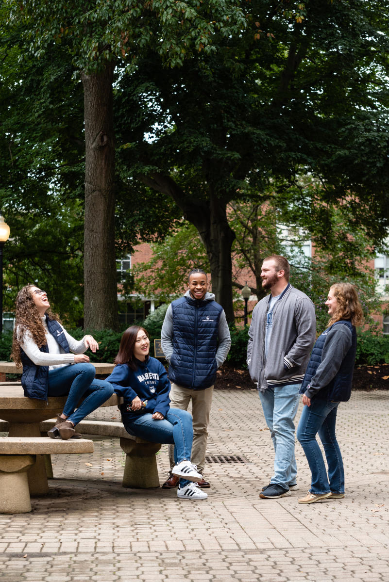 Students sitting around campus and laughing