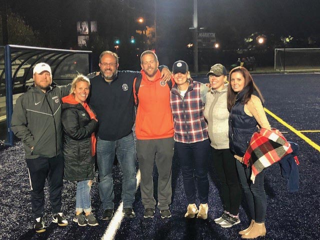 Marietta College Alumni take a group photo at a soccer game