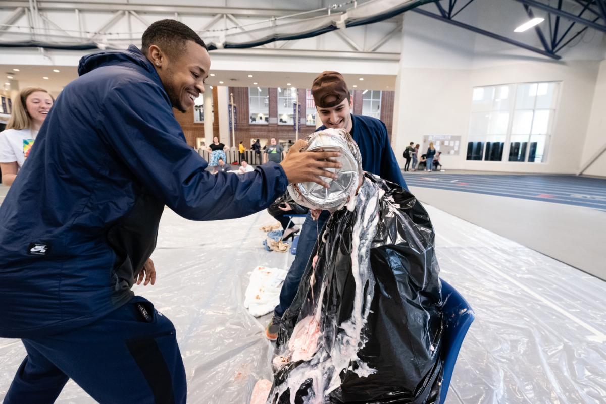 Mel Shuler ’19 (left) and Joe Hall ’19 celebrated the last day of spring semester classes during FunFest Friday, including participating in Brother 2 Brother’s Pie in the Face fundraiser.