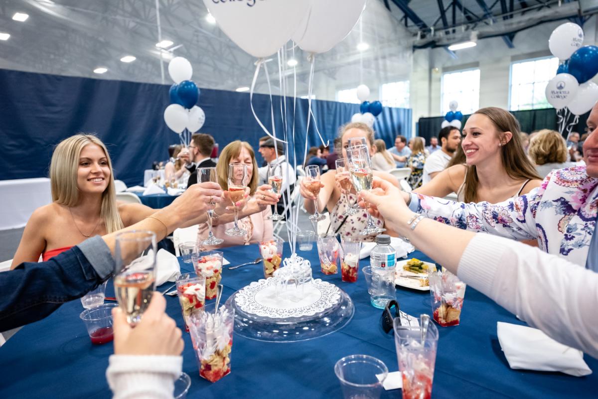 Megan Horsley ’19 (far left) and Amanda Arrowood ’19 (far right) toasted their pending graduation with family members during the College’s Strawberries & Crème luncheon.