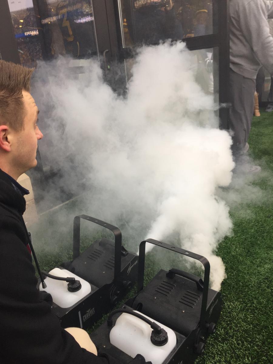 Brett Mattson '18 at WVU Job Shadow operating fog machine during team entrance