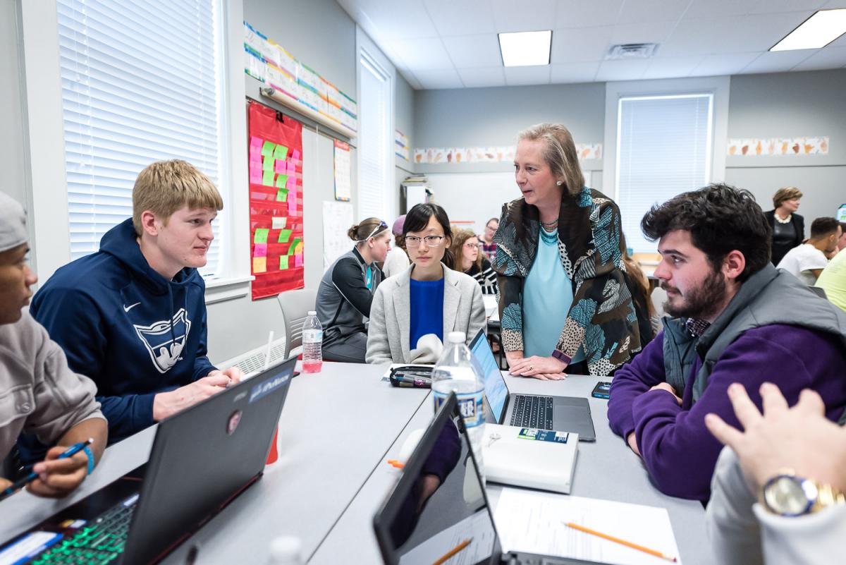 Dottie Herb of Marietta College talks with a table of students in the classroom