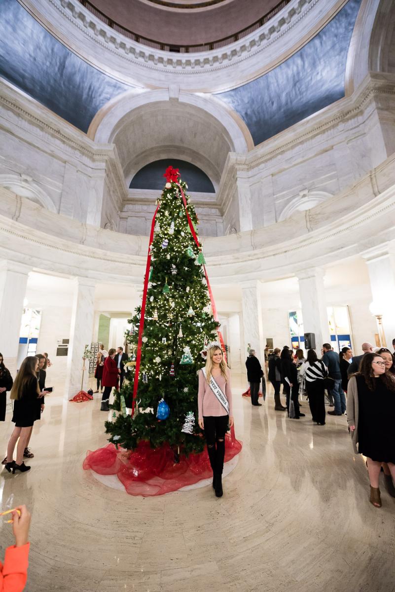 Casey Lassiter '18 Poses in front of a Christmas Tree during a tree lighting ceremony