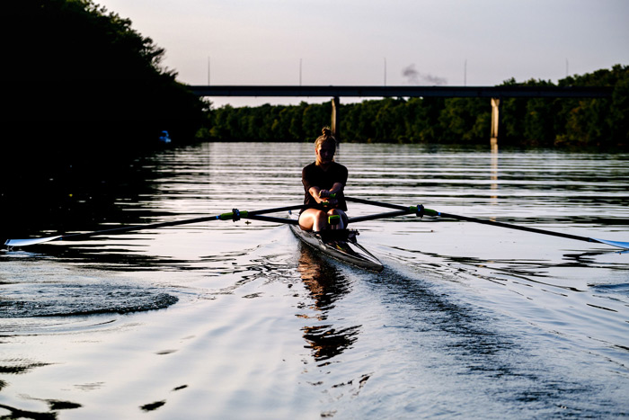 Single woman rowing on the river