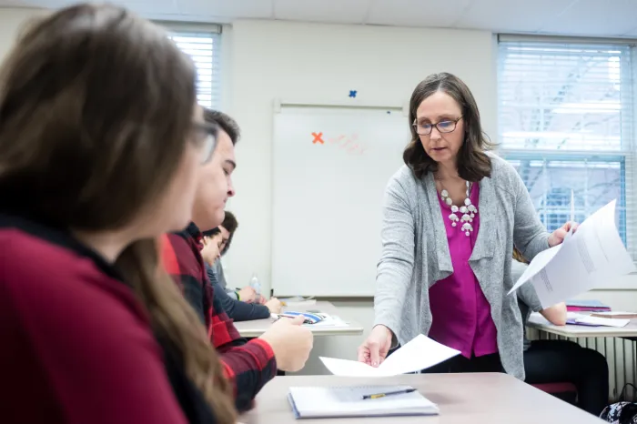 Female faculty member handing back an assignment to a student