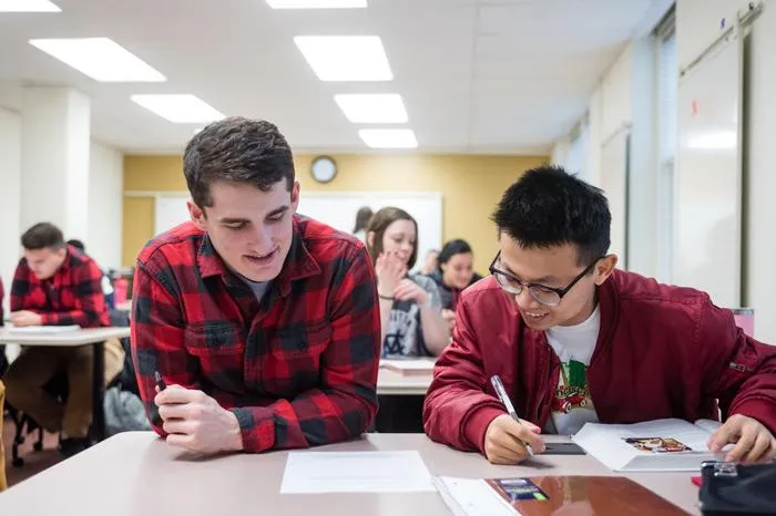 Two male students working together in class