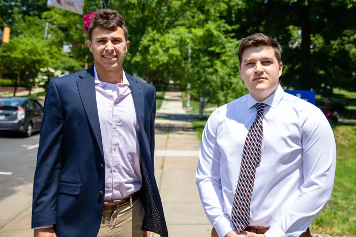 Eric DeLong and Logan Isner standing outside