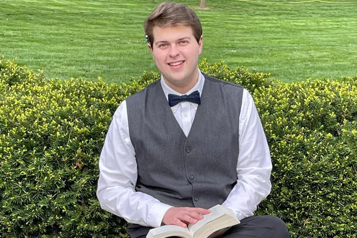 Tyler Hartline sitting with a book