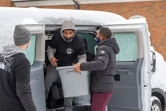 Students loading boxes in a van