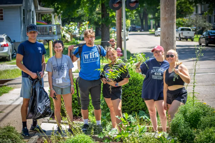 Six Marietta College students working outside on a landscaping service project