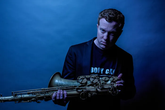 Adam Larson posing with a saxophone