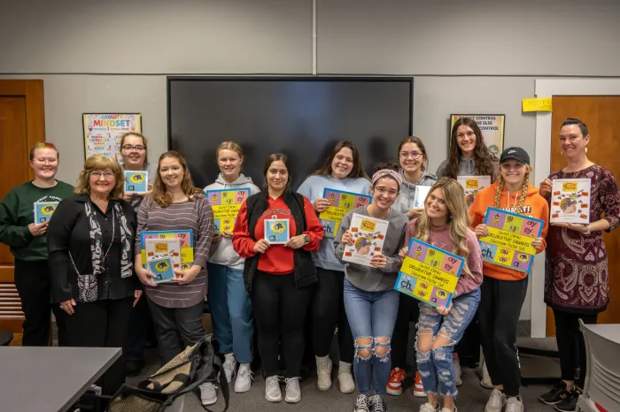 Students holding up the book