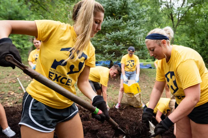 Marietta College students shovel dirt during Make a Difference Day