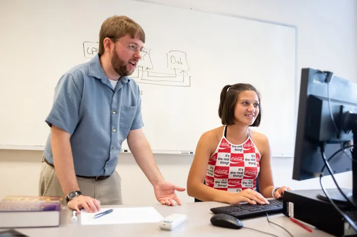 Faculty member helping a student on a computer