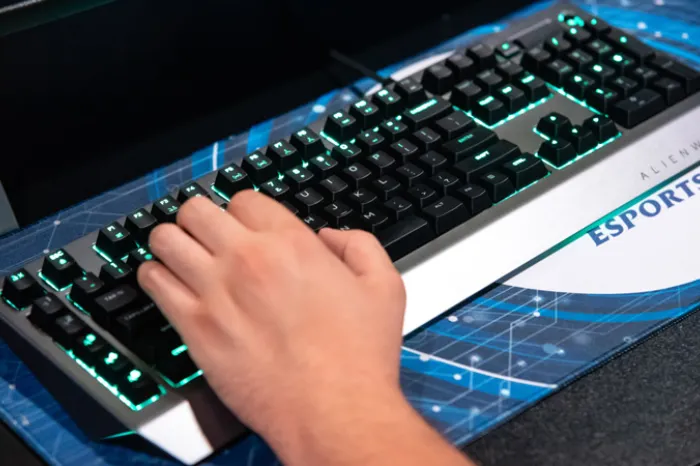 An esports player's hand on a keyboard