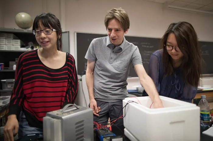 Physics students working with a professor