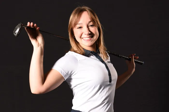 Golfer with club behind her head