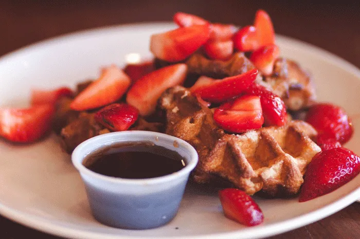 Strawberries and syrup on waffles