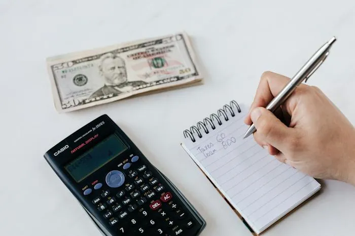 Money, calculator and notepad on a table