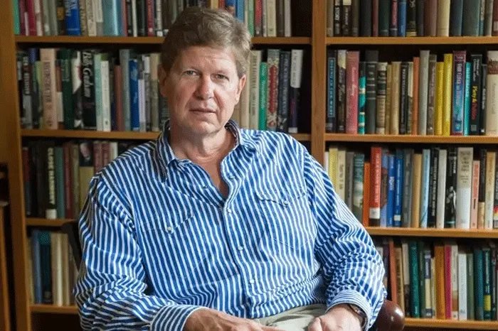 Randall Balmer seated in front of a bookcase