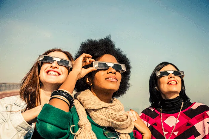 Women wearing eclipse glasses