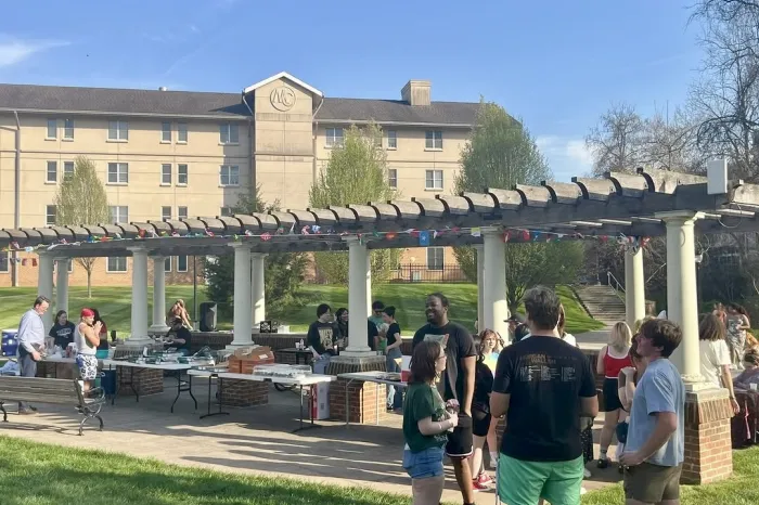 Students gather on Harrison Lawn with refreshments, cultural decor